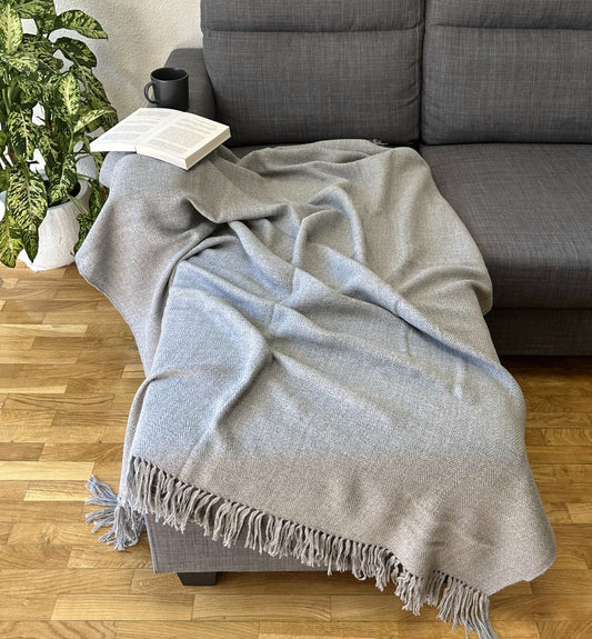 Hand-knitted solid grey baby alpaca blanket. Measures 180 cm in length by 130 cm in width.