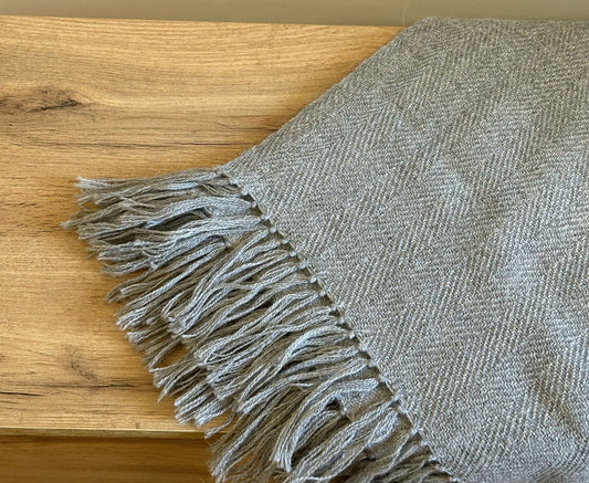 Hand-knitted solid grey baby alpaca blanket. Measures 180 cm in length by 130 cm in width.
